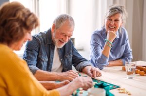 A group of three seniors playing board games and socializing