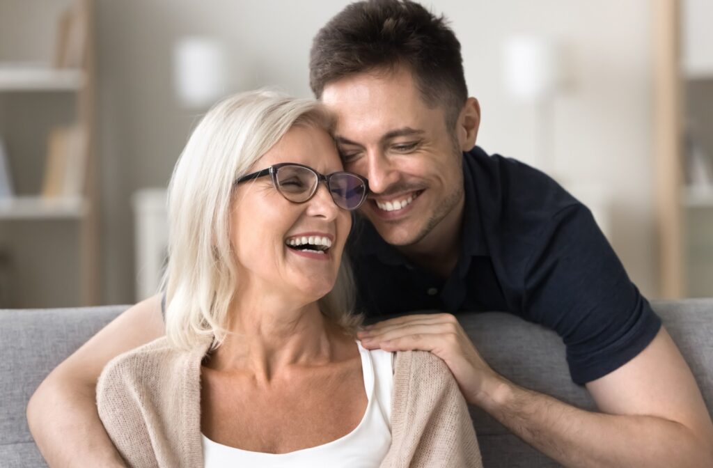 An adult child embracing their mature parent, who is experiencing early symptoms of dementia.