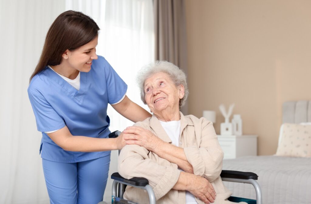 A caregiver smiles at a senior resident in memory care.